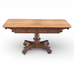Victorian rosewood library table, rounded rectangular top with two frieze drawers with turned wooden knobs, quatriform base with scrolled ends terminating in brass castors  