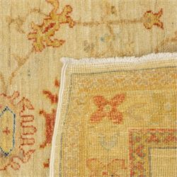Cream ground prayer rug, with red and blue stylised motifs within a broad floral border, the field with central mihrab-style design in soft red, blue and beige tones
