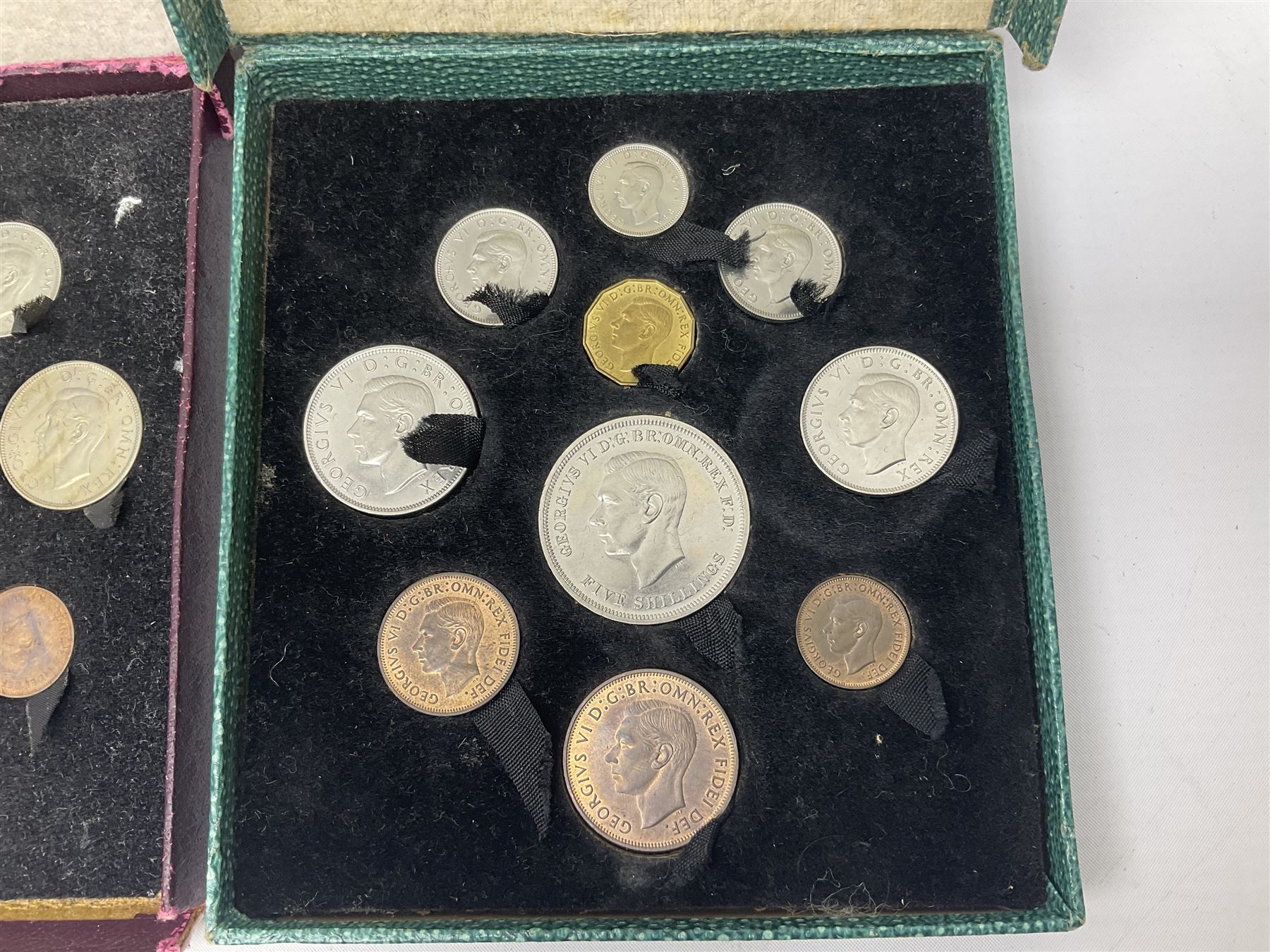Three King George VI 1951 'Festival Of Britain' specimen coin sets, each comprising farthing to crown coins, housed in maroon, green and blue dated boxes 