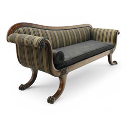 Regency brass inlaid rosewood chaise lounge or settee, shaped back over rolled head and foot, upholstered in black and gold striped fabric with rectangular squab cushion and bolster cushion, the rolled terminals carved with acanthus leaf roundels, lower rectangular foliate carved panels, on out splayed supports with paw carved feet 