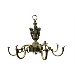 Early 20th century cast brass chandelier, the main baluster-form body surmounted by a lobed finial, with three cherubic heads and foliate scrollwork around the upper section, eight sweeping branches for lights