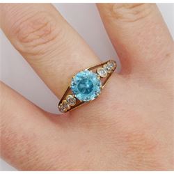 Early 20th century gold round blue zircon ring, the pierced shoulders set with five round graduating old cut diamonds either side, stamped 18ct 
