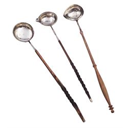 Georgian toddy ladle with silver tapering oval bowl and later turned wooden handle, engraved with initials to underside of bowl, hallmarked London, probably 1734, maker's mark indistinct, H39cm, together with two Georgian toddy ladles with silver bowls and baleen twist handles, the first example with circular bowl marked CB, H35.5cm, the second example with oval bowl and spout, unmarked but testing as silver, H35.5cm