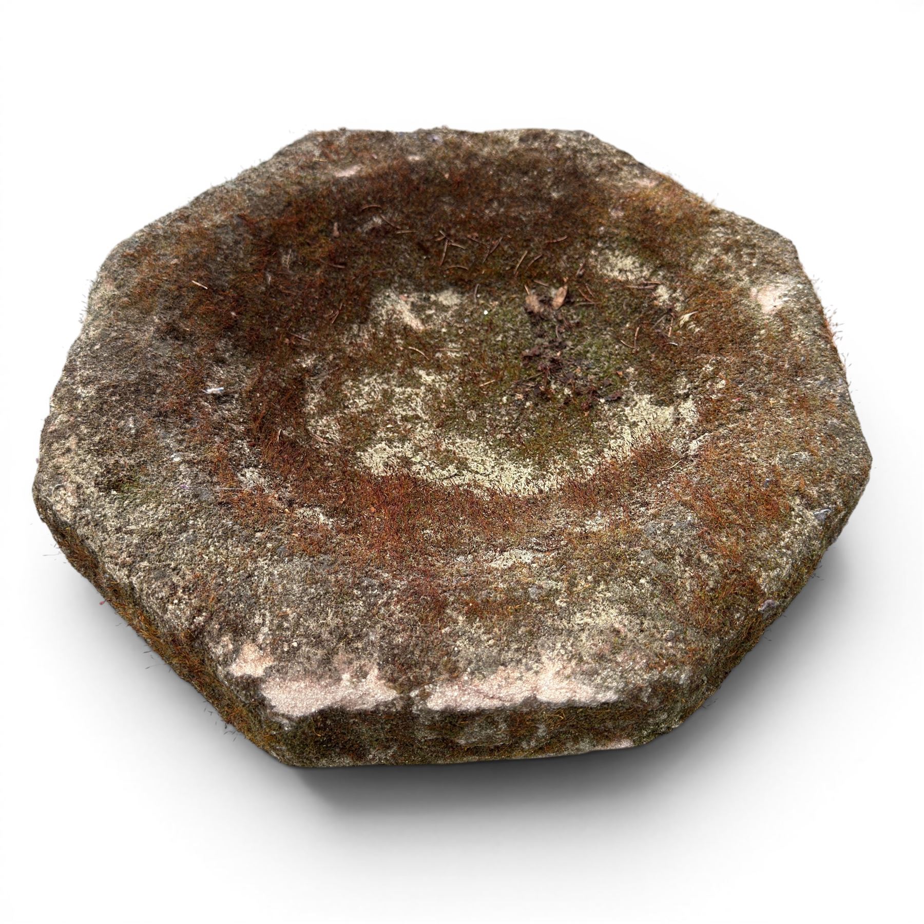19th century weathered sandstone birdbath, the octagonal canted dished top raised on a ring turned flared pedestal, with four carved stylised dolphins to the squared base