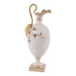 Royal Worcester Blush Ivory ewer, on a gilt square foot with a gilt crimped rim and high arched handle and mask, painted with gilt foliage shape 1144, together with fluted ewer decorated with gilt flowers shape 1361, both with puce mark beneath, largest H29cm
