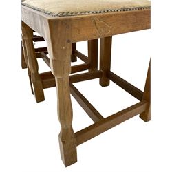 'Eagleman' set four oak dining chairs, adzed panelled backs, upholstered seats with stud work band, the side rails relief carved with inset eagle signature, shaped octagonal supports joined by stretchers, by Albert Jeffray of Sessay, Thirsk