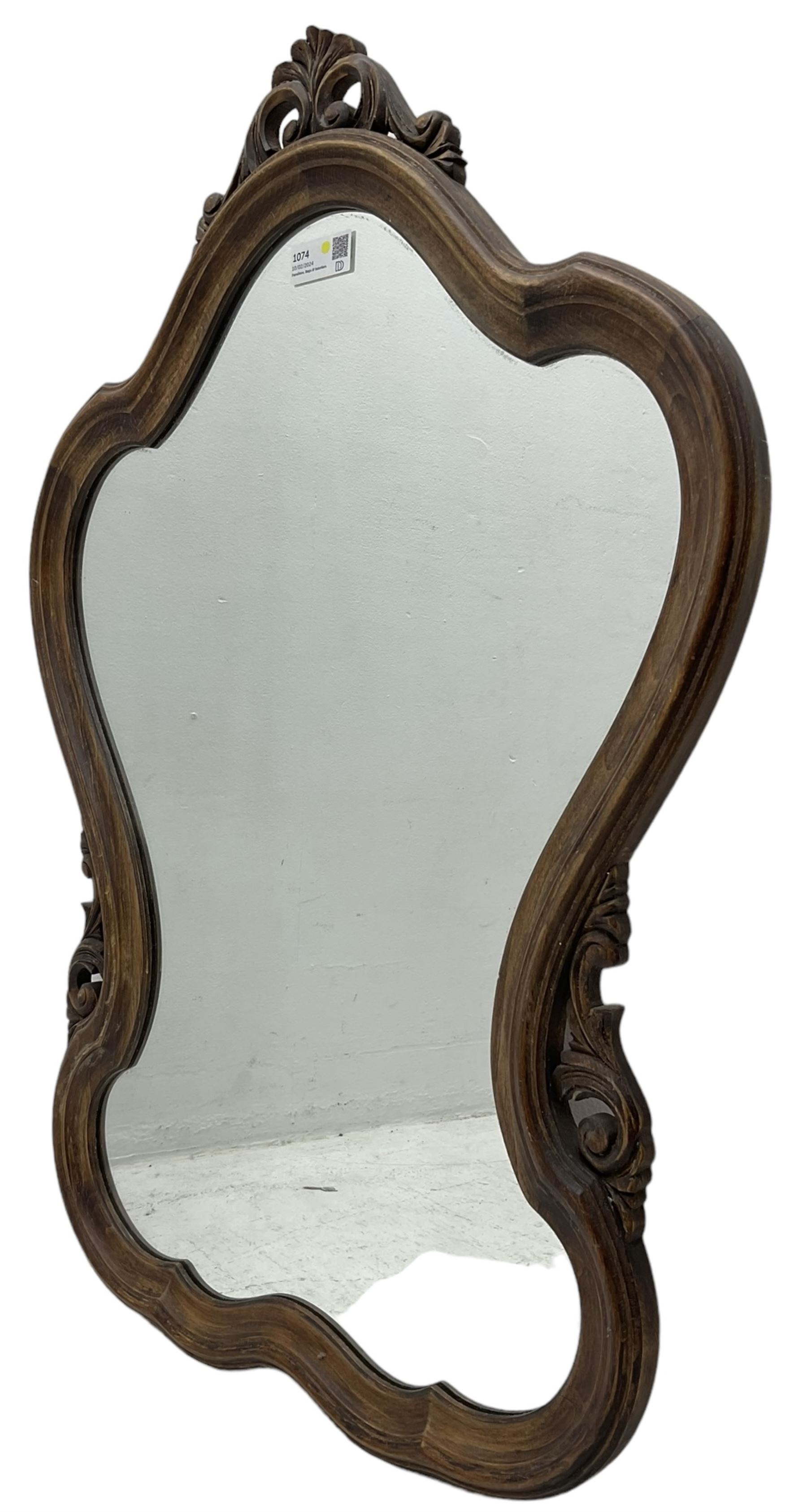 French design stained beech framed wall mirror, shaped and moulded framed with scrolling foliage carved pediment and brackets, plain mirror plate 