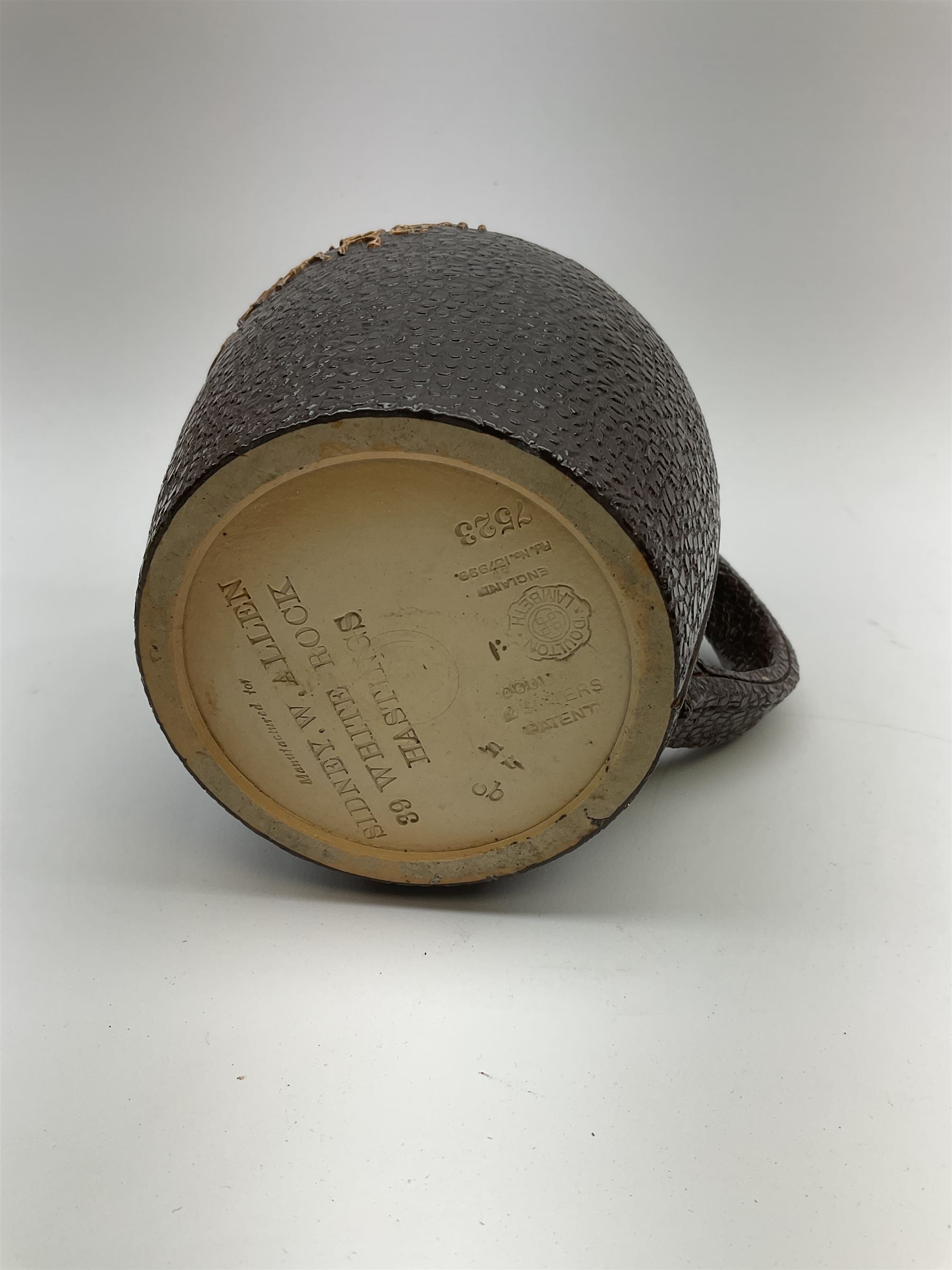 A Doulton Lambeth stoneware jug, with silver mounted collar, hallmarks rubbed, maker's mark probably Cornelius Desormeaux Saunders & James Francis Hollings (Frank) Shepherd, the leather effect body titled 'Drinke Faire Don't Sware', with impressed marks beneath including 'Manufactured for Sidney W Allen 39 White Rock Hastings', H18.5cm. 