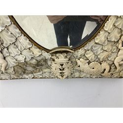Pair 19th century French Dieppe bone and ivory wall mirrors, the oval bevelled mirror plates within rectangular frames with shaped tops, profusely decorated with ivory leaves, further detailed with carved bone armorial type crest inscribed 'SGOTORVM', putti, fish and mask heads, H81cm W48cm