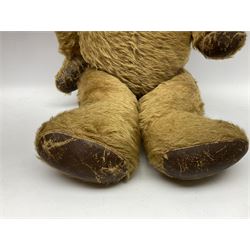 Mid-20th century plush covered teddy bear the revolving head with applied eyes, vertically stitched nose and jointed limbs with rexine pads H58cm; together with a leather backpack (2)