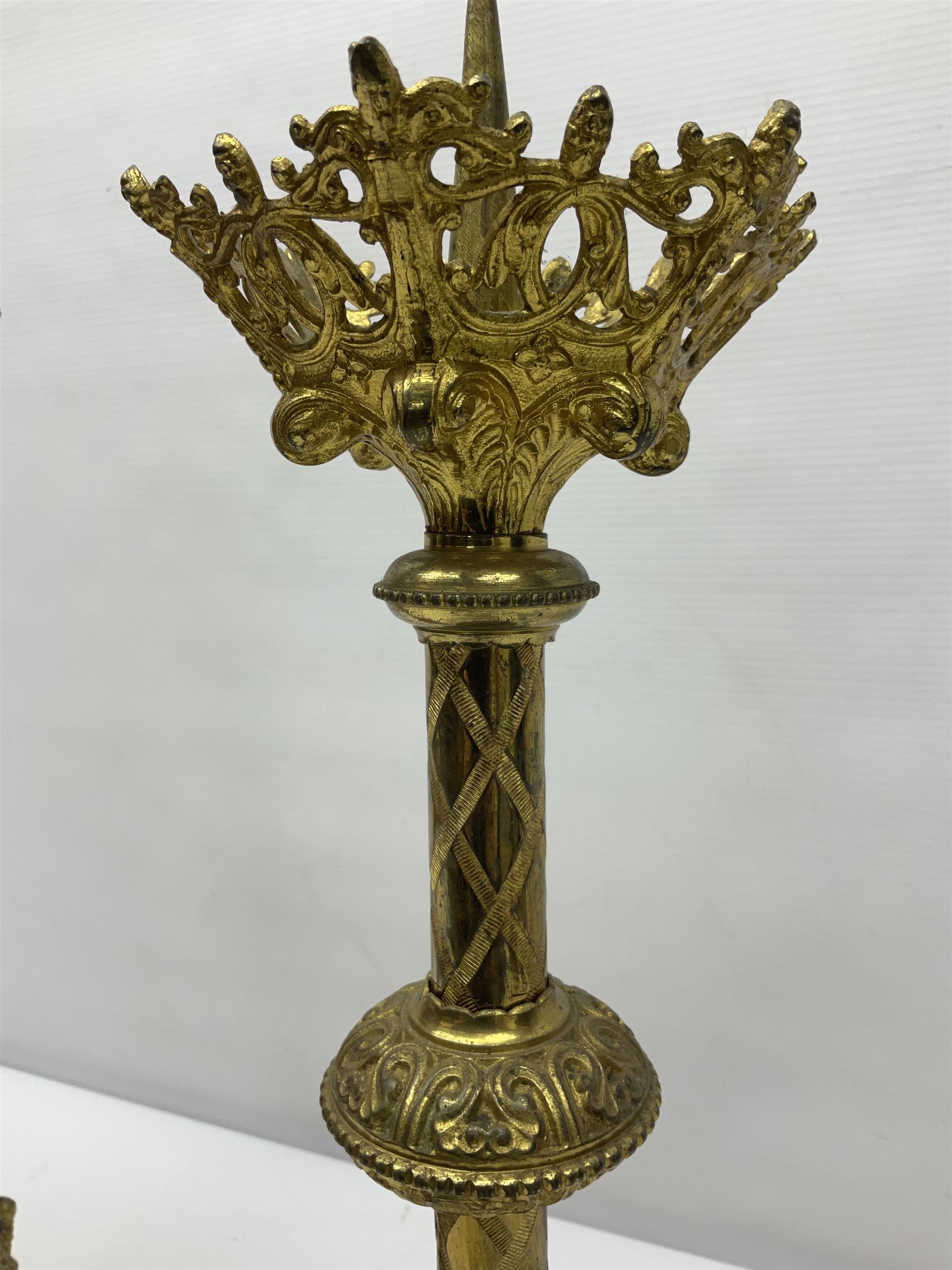 Pair of gilt metal pricket candlesticks, with applied decoration on knopt stems and triform bases, H47cm