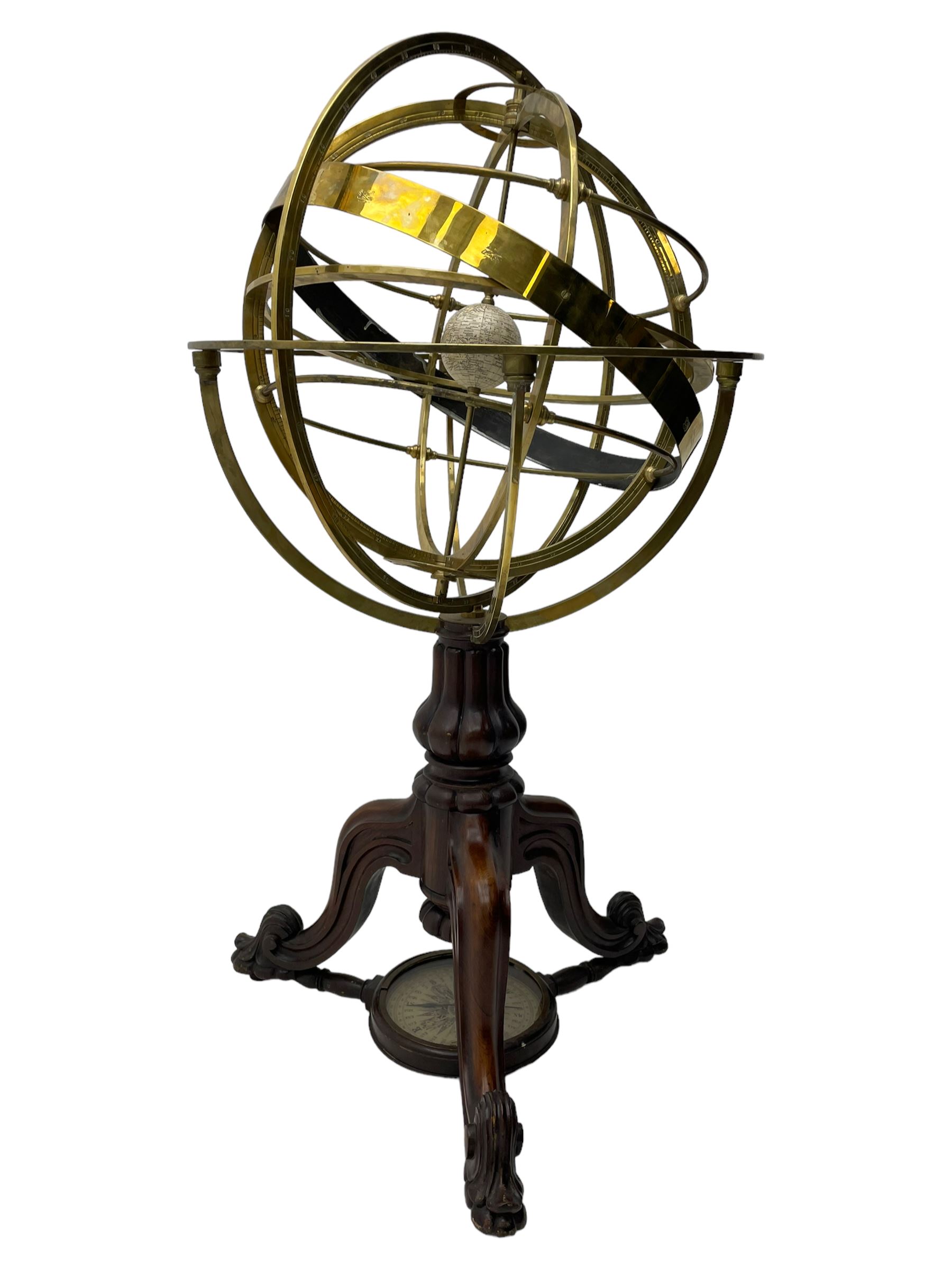 19th century brass terrestrial armillary sphere on rosewood base, lobe carved column on three splayed supports with scrolled carved terminals, the supports united by circular compass with turned stretchers