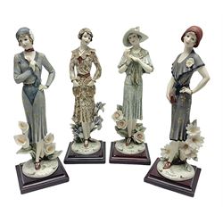 Set of four Giuseppe Armani Florence figures, Iris, Rose, Lily and Daisy, each modelled as ladies in 1920s dress amongst flowers, with names and signature inscribed and upon mahogany base, H23cm