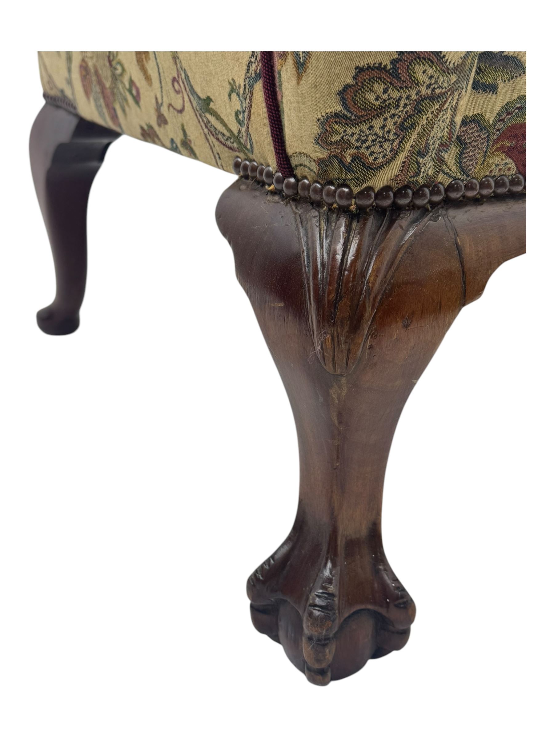 Mid-20th century William and Mary design two-seat sofa, upholstered in floral patterned fabric with contrasting piping, featuring camel-shaped back and scroll arms, on cabriole supports