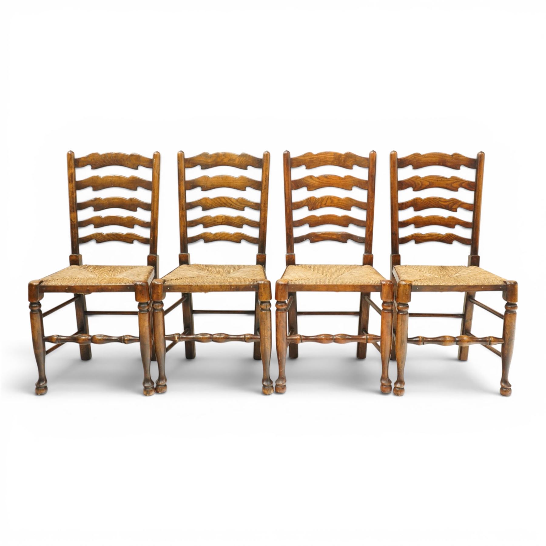 Set of eight country ladderback chairs (6+2), shaped ladderback over a rush seat, raised on turned supports, united by stretchers