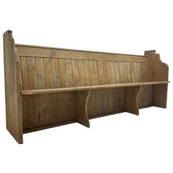 Early 20th century pine church pew, vertical plank back over rectangular seat, flanked by shaped end supports, with bible rest to back