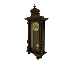 A 19th century German 8 day striking wall clock manufactured by HAC (Hamburg Amerikanische Uhrenfabrik) in a mahogany case with a wide cornice top, carved pediment and turned finial, full length glazed door flanked by turned half columns with corresponding pendant finials beneath, eight day spring driven movement striking the hours and half-hours on a coiled gong (missing), with a two piece dial, enamel chapter ring and gilt centre, spun brass bezel and decorative pierced steel hands, with a visible “gridiron” pendulum with regulation. H90cm


