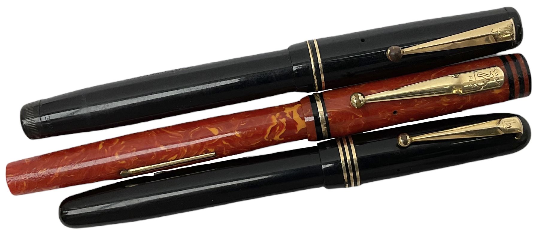 Vintage Swan Mabie Todd lever fill fountain pen in coral red, the nib a/f marked 14K, together with two further vintage Swan Mabie Todd fountain pens, the first example with lever fill, the other leverless, each with black body, one with nib marked 14ct, (3) 