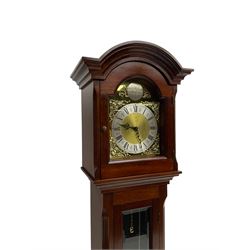 Mahogany cased Grandmother clock c 1980 made and retailed by Julian Stanton, Winchester, with a break arch pediment and corresponding brass dial, full length glazed door displaying three brass cased weights and pendulum, raised on a square plinth with a recessed panel and skirting, German Kieninger three train chain driven movement striking the hours and quarters on 12 gong rods. With weights and pendulum.  