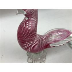 Three Murano style glass cockatoo parrots, the first with mottled yellow, red and orange body, clear outstretched wings, dark blue beak and red crest, raised upon clear stylised base, the second smaller parrot with merging blue and green body, and further with pink striped body, tallest H40cm