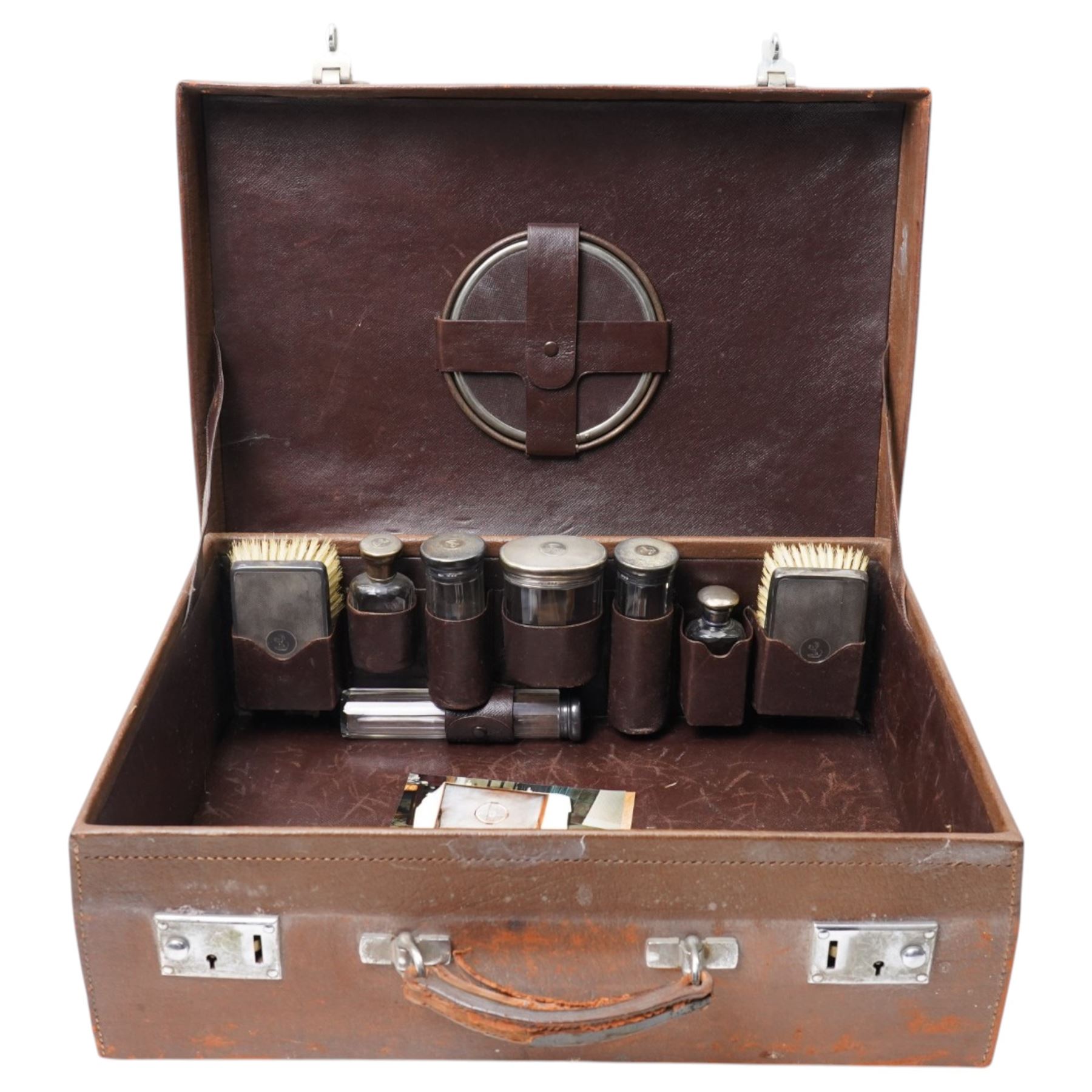 Leather dressing case with silver mounted brushes and glass bottles engraved with the Starkey crest W49cm London various dates circa 1930, Maker G H James & Co