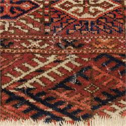 Central Asian Turkmen Tekke hand-knotted rug, madder red field decorated with rows of octagonal guls linked by secondary motifs within a dense geometric border, with fringe ends  