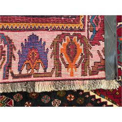 South West Persian Qashqai red ground runner, the crimson field decorated with three connected lozenges, surrounded by small stylised motifs of bird and plants, indigo spandrels with further stylised motifs, the border with repeating floral design 