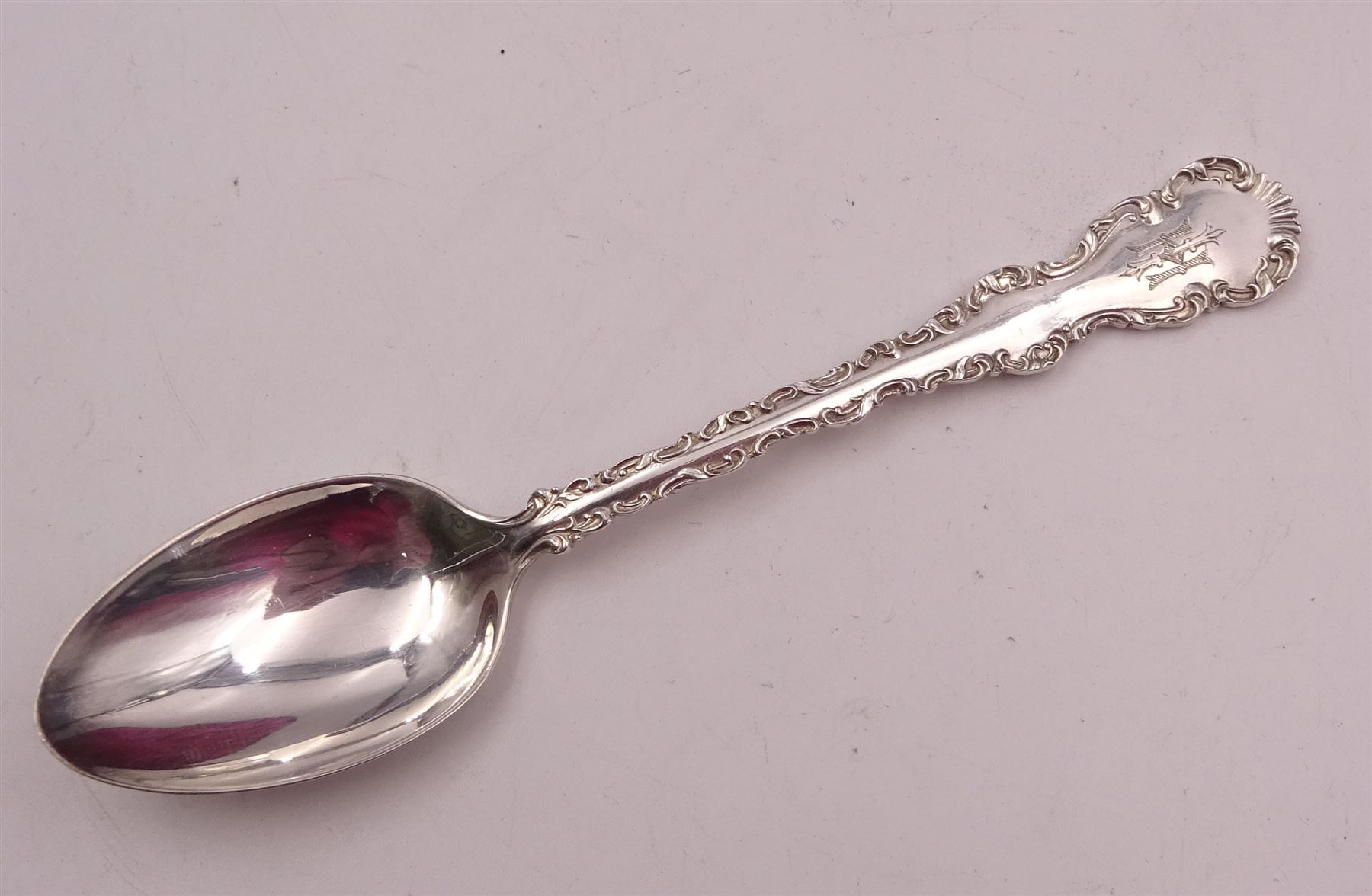 Set of ten Victorian silver coffee spoons, each with shaped scroll design rim, and a matching pair of sugar tongs, hallmarked Lee & Wigfull, Sheffield 1897, in tooled leather burgundy velvet and silk lined fitted case 