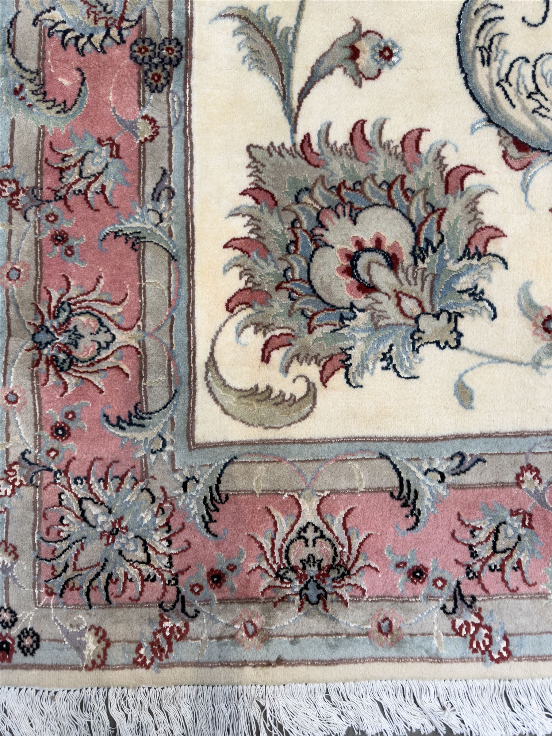 North East Persian Kashmar hand-knotted rug, ivory field with an all-over design of linked floral medallions and scrolling vines with a central circular medallion enclosed by multiple borders and a main broad madder field with palmettes and arabesques, 248cm x 145cm