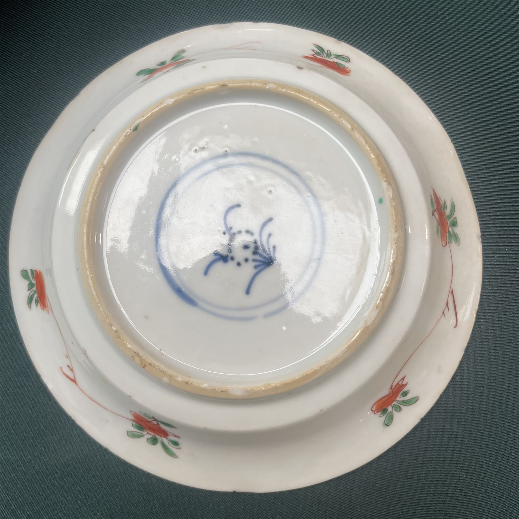 Three Chinese famille verte examples, approximately Yongzheng period, to include two teabowls and two saucers, each decorated with flowers and butterflies, two with sacred fungus mark within double rings, the teabowl with lotus mark, the other indistinct - possibly a Wan mark within lozenge (4)