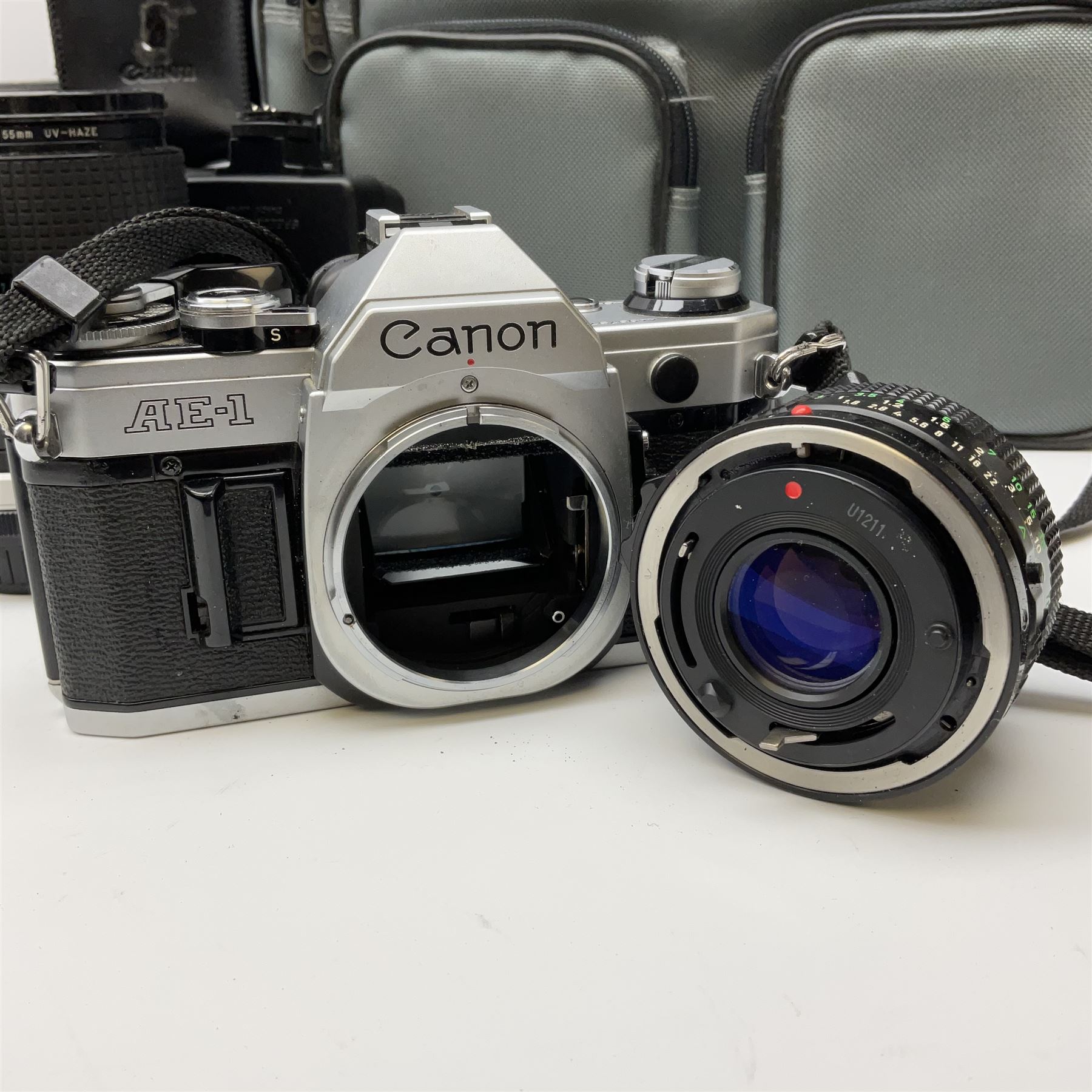 Canon AE1 camera, 'no. 4403757', fitted with Canon 'FD 50mm 1:1.8' lens, Hoya 'HMC Wide-Auto f24mm 1:2.8' lens and various other lenses and camera accessories, housed in a soft carry bag