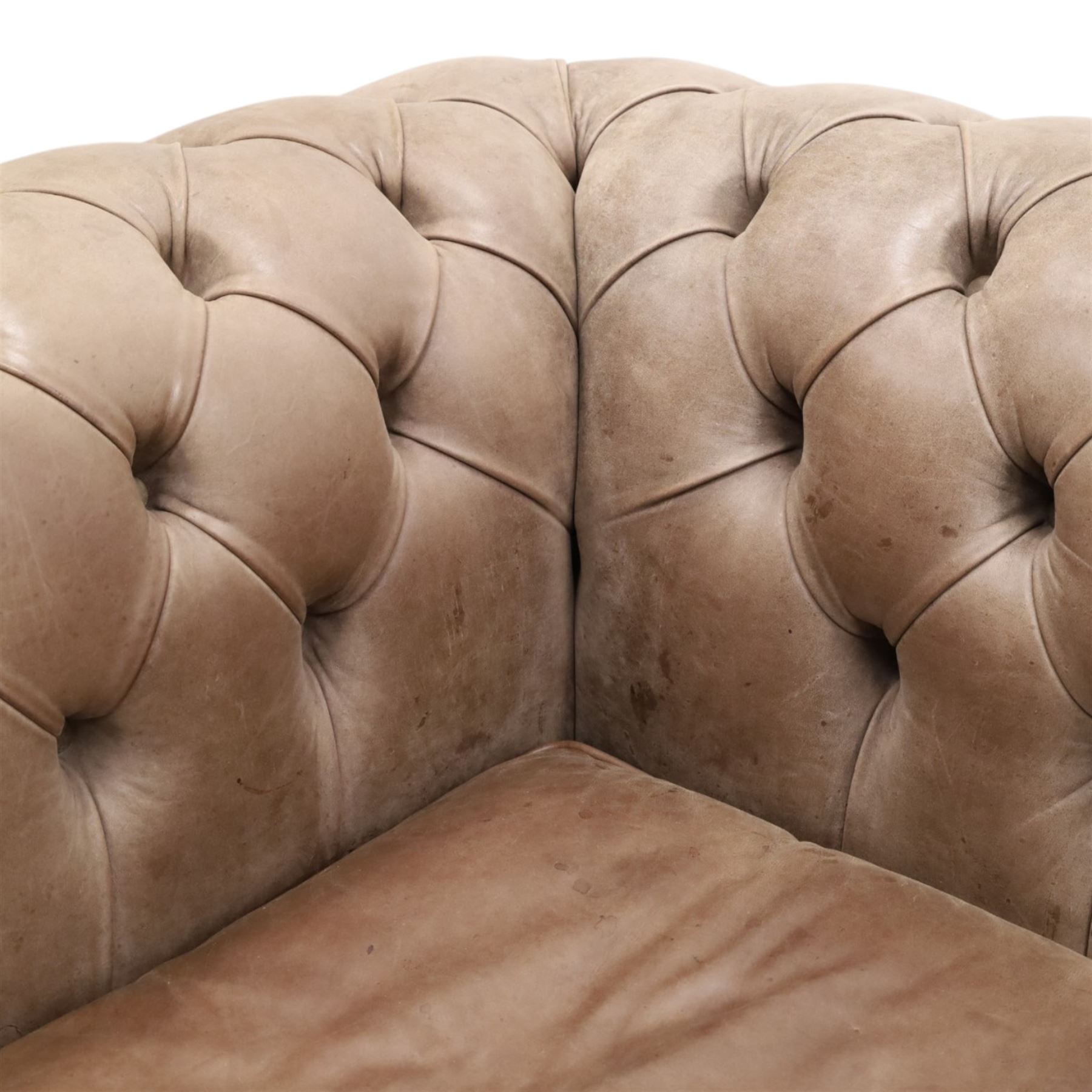 Distinctive Chesterfield - Chesterfield upholstered in taupe leather, deep button back and arms, loose seat cushions, raised on dark stained supports 