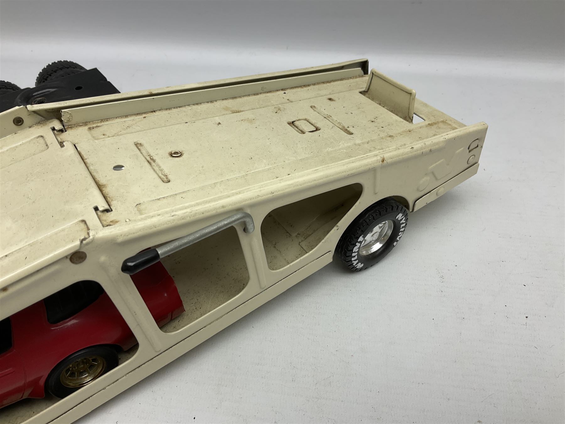 American Nylint large scale tin-plate car transporter L59cm carrying a Testor Toys plastic car; Tonka tin-plate mobile crane; boxed Sarony Cigarettes tin-plate roulette game with rules; and Japanese style tin-plate box, the lid inset with a revolving poker dice game (4)