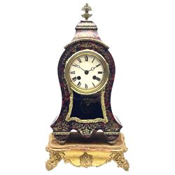 19th century brass inlaid red Boulle work mantel clock on ornate gilt stand, cartouche shaped case with floral urn finial, circular white enamel Roman dial above window, mask cast pendulum, ornate foliate moulded slip, twin train eight day movement striking on bell by Japy Freres, the gilt serpentine stand with scroll shell cartouches 