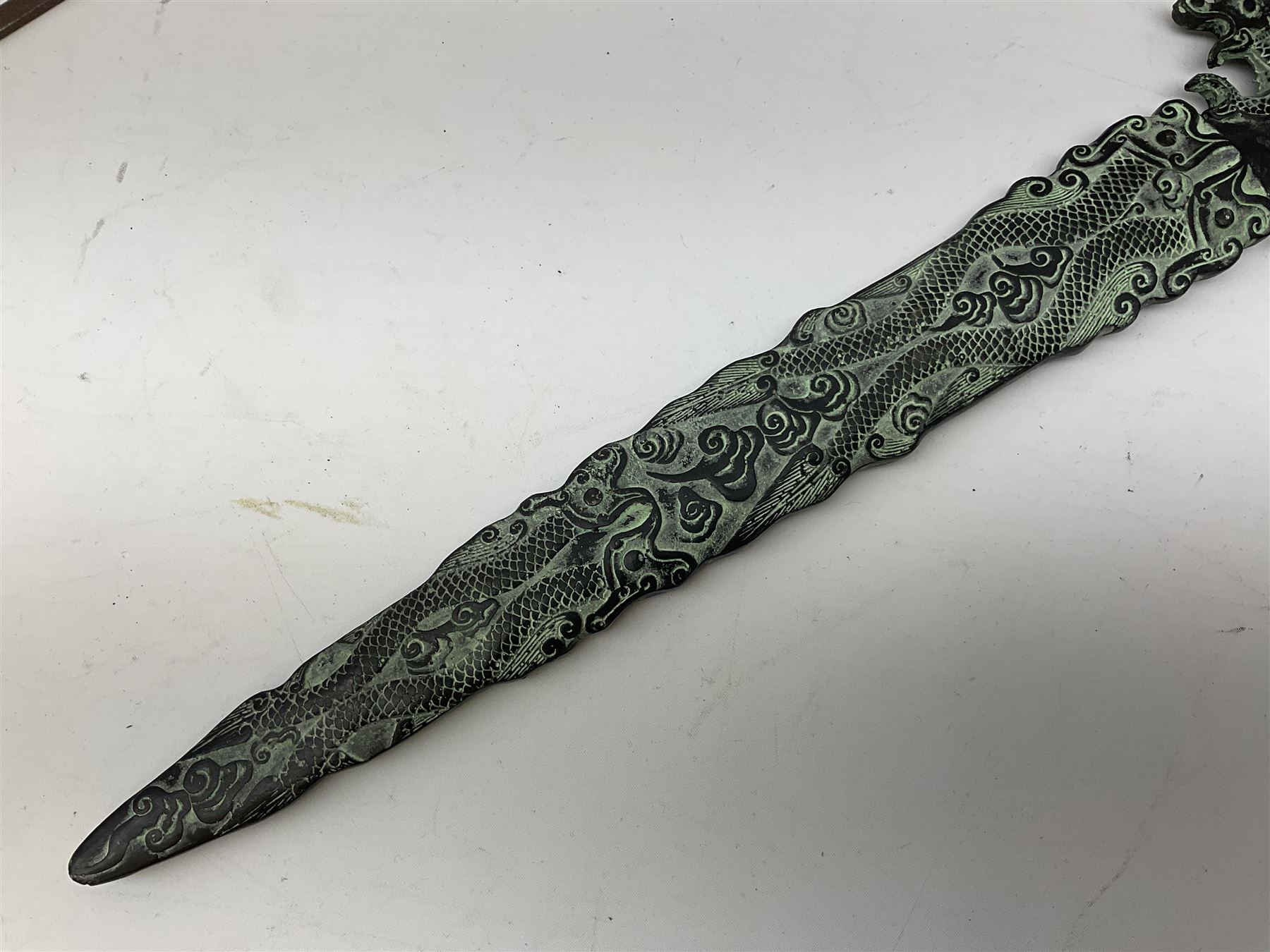 Patinated 'bronze' fantasy dagger, the 26cm blade, hilt and scabbard cast with dragons L50cm overall; hand forged iron spearhead L29.5cm; and a stiletto blade (3)