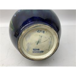 Moorcroft vase of baluster form decorated in the Spring Flowers pattern upon a merging green and blue ground, with impressed and painted marks beneath, H22.5cm