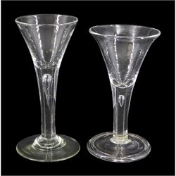 Two 18th century drinking glasses, the drawn trumpet bowls upon stems with internal tears, one elongated, and conical feet, one folded, largest H16cm