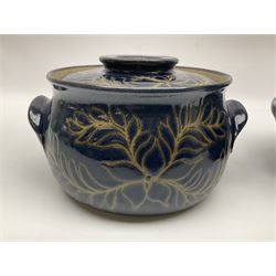 John Egerton (c1945-): set of two studio pottery stoneware twin handled jars with covers, decorated with floral and foliate sprigs upon a dark blue ground, D23cm, H15cm