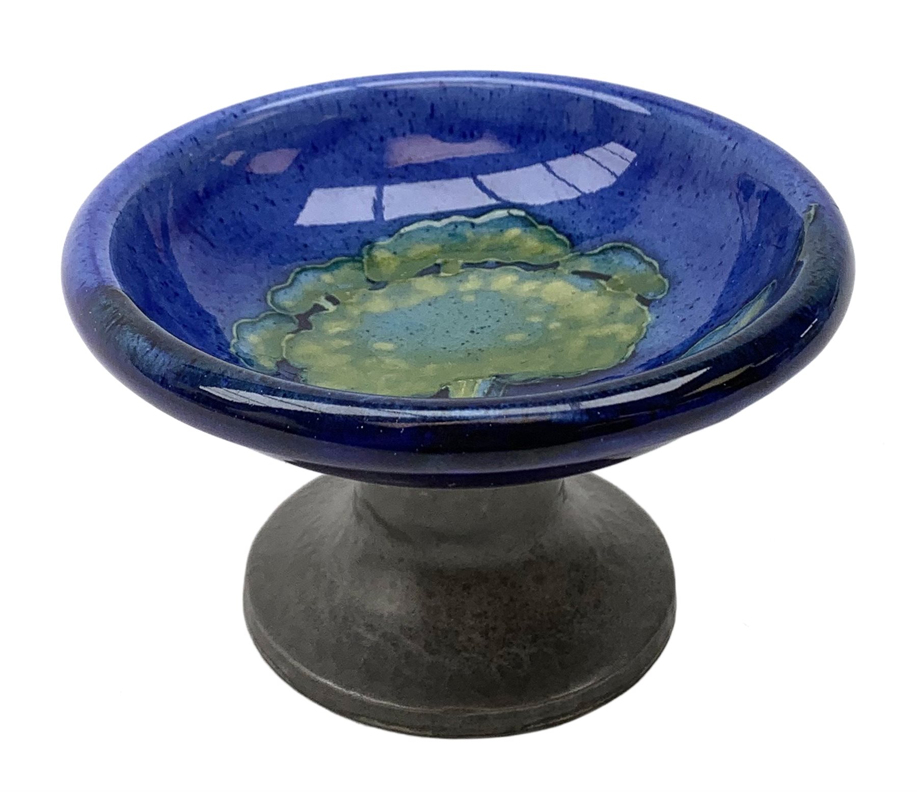 William Moorcroft for Liberty & Co, small pedestal dish, the shallow bowl decorated in the Moonlit Blue pattern, raised upon a Tudric pewter base, impressed beneath Made in England, Tudric Moorcroft 01339, H7cm, D11cm