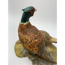 A North Light figure modelled as a cock and hen pheasant upon rocky ground, signed J Stanbridge 82, H26cm L30cm