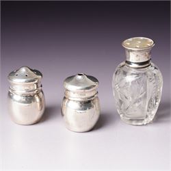 Small glass scent bottle with silver and red enamel cover, Edwardian silver cased scent flask with engraved decoration, heptagonal silver napkin ring, pair of small silver barrel shape salts, glass pepperette with silver and mother of pearl cover, small silver stone set fork by William Robb and a silver salt spoon