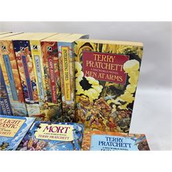 Collection of books by Terry Pratchett, of mostly Discworld interest, to include hardback edition of Going Postal, and further books such as Men at Arms, Sourcery, Small Gods etc 