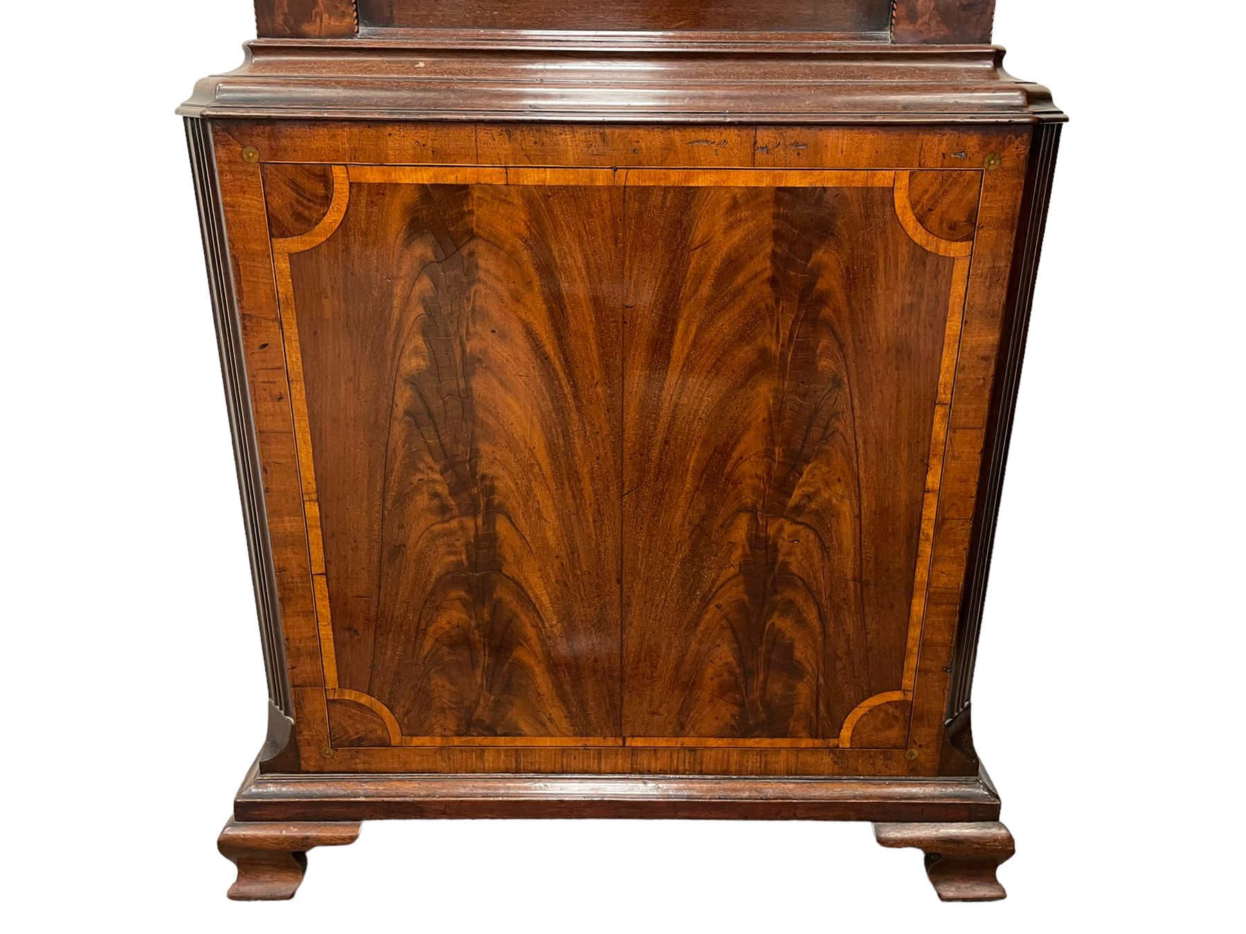 Penlington of Liverpool – early 19th century 8-day mahogany longcase clock, swans neck pediment with three turned wooden finials and verre eglomise panels, trunk with reeded columns and wavy topped door, plinth with canted corners on bracket feet, painted break-arch dial with Roman numerals and five-minute Arabic’s, centre sweep calendar and seconds hands, blue steel serpentine hands, signed beneath a painted rolling moon in the arch PENLINGTON, LIVERPOOL, eight day four pillar movement, anchor escapement and rack striking on a bell. With pendulum and weights.  The Penlington family were prolific clockmakers in 19th century Liverpool working from several addresses in the city, also recorded as chronometer and chronograph makers.