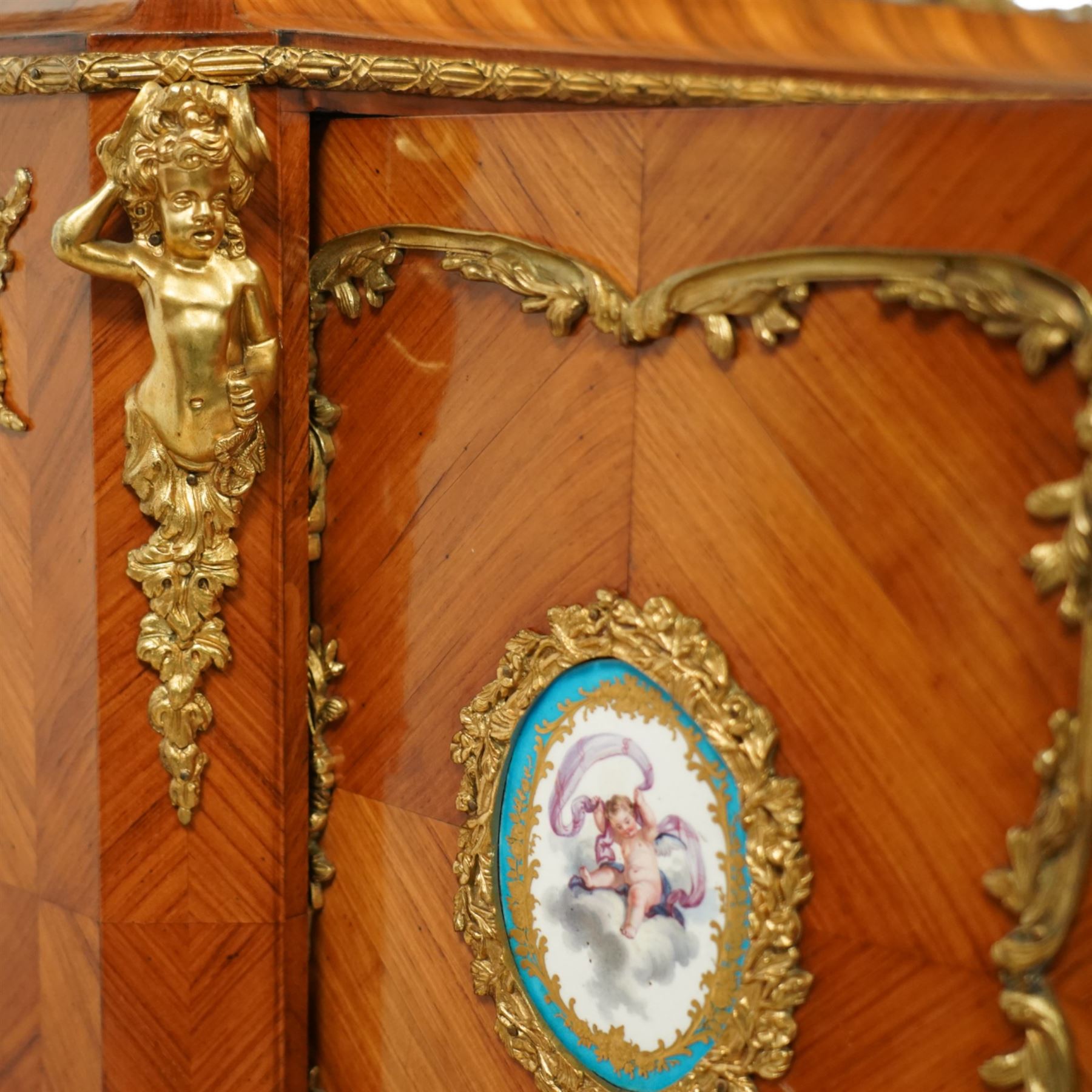 Late 19th century French Louis XV style kingwood and ormolu mounted bonheur du jour, the upper section with a pierced three-quarter gallery over a pair of cupboard doors inset with Sèvres-style porcelain portrait plaques, enclosing a shelved interior over two short drawers, the serpentine top and apron richly mounted with gilt-bronze foliate and scroll motifs, single frieze drawer below on cabriole supports with acanthus cast sabots