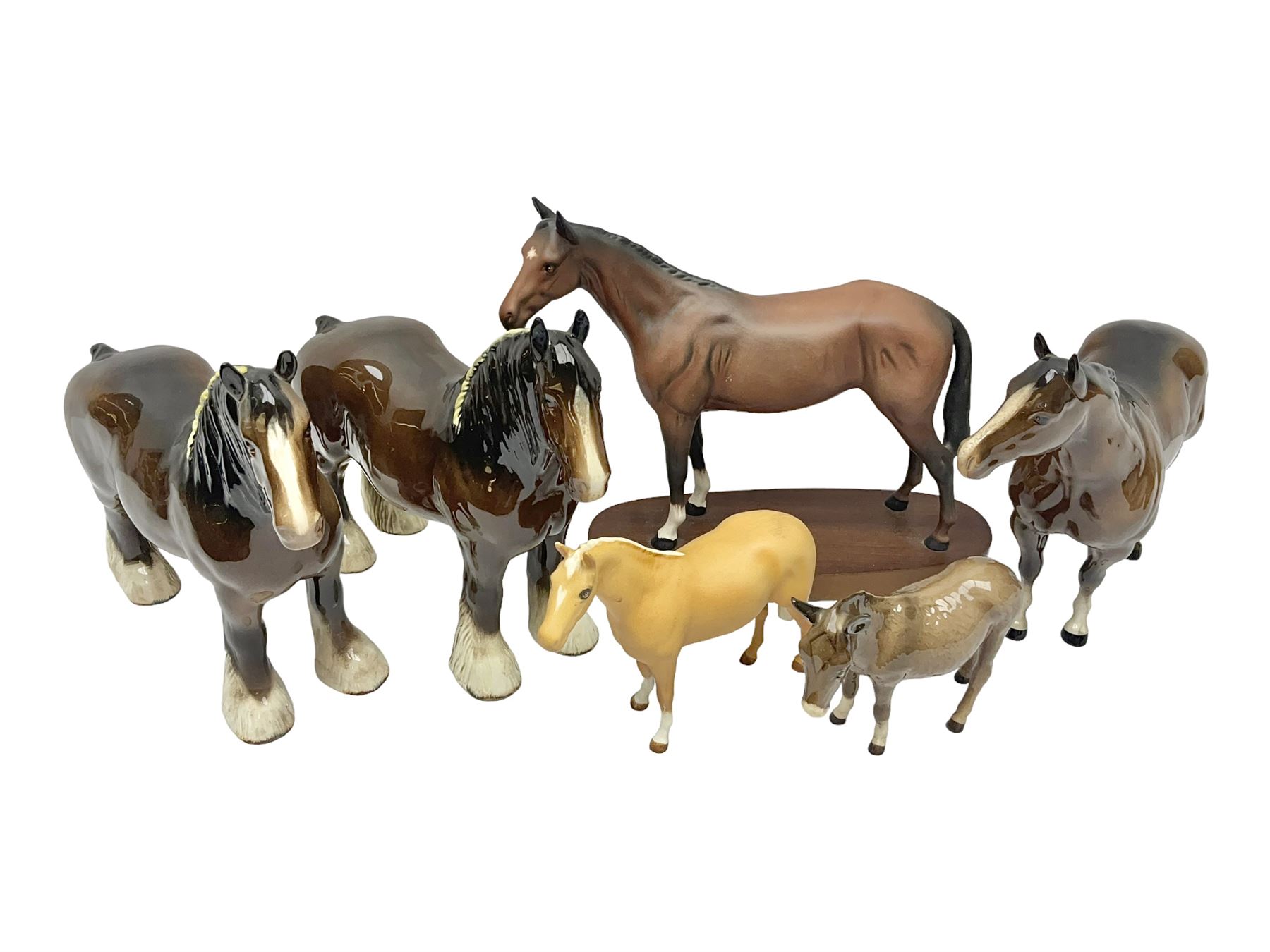 Four Beswick horse figures, comprising Quarter Horse, two Shires no 818 and matt palomino, together with Beswick donkey and Royal Doulton horse on a wooden plinth  