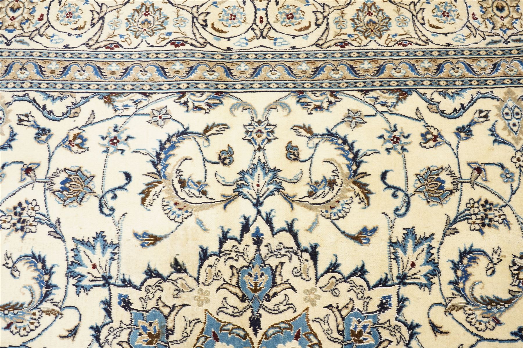 Central Persian Nain hand-knotted carpet, ivory field with central radiating medallion, issuing an all-over design of scrolling vines, palmettes, and delicate floral sprays with conforming spandrels, enclosed by a foliate border, framed by multiple guard stripes, with cotton fringe ends 