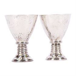 Pair of 20th century Greek silver metal goblets, each with planished tapering bowl upon a knopped stem and stepped spreading foot, marked Lalaounis 925, H10.5cm
