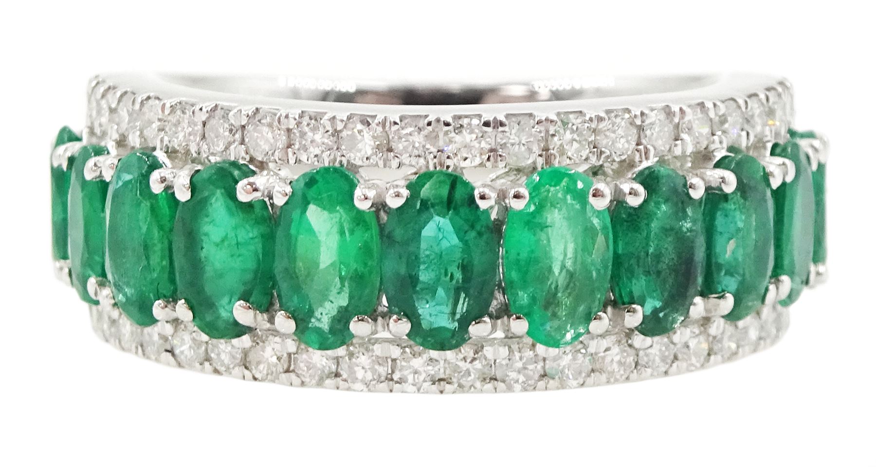 Platinum three row emerald and diamond half eternity ring, eleven oval cut emeralds with a row of round brilliant cut diamonds either side, hallmarked, total emerald weight approx 2.50 carat, total diamond weight approx 0.45 carat