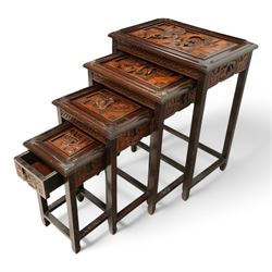 Carved hardwood nest of four occasional tables, each with rectangular top carved with figural scenes, on square supports with hoof terminals united by stretchers 