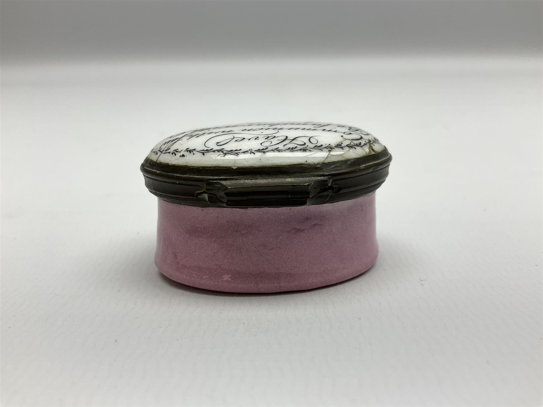 Late 18th century Staffordshire enamel patch box, of oval form with pink base, the hinged cover inscribed 'Have Communion with few, Be familiar with One, Deal justly with All, Speak evil of none' upon a white ground, opening to reveal mirror beneath, W4cm